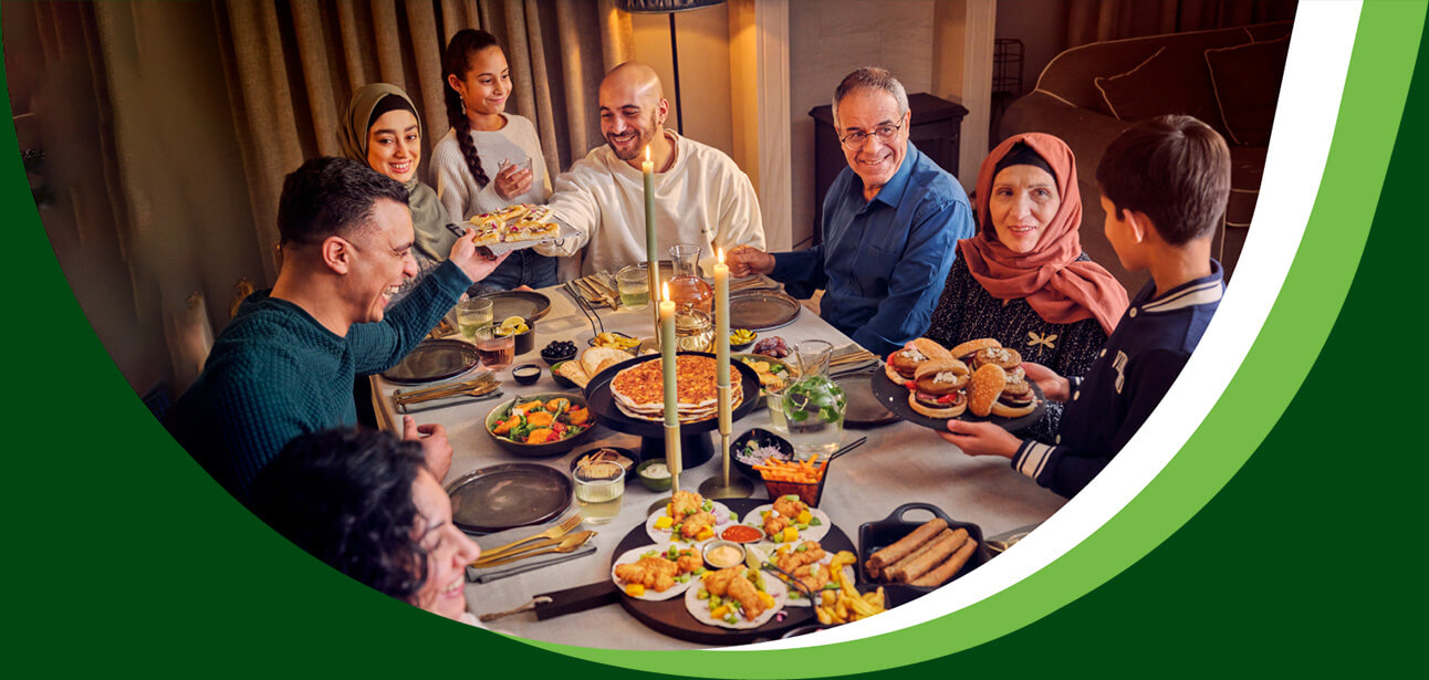 Familie van acht met grootouders, ouders en kinderen aan tafel met veel eten